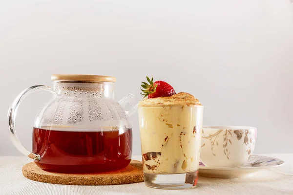 Tiramisu in a glass Cup, glass teapot and Cup and saucer 免版税图库照片