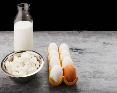 Süt, yumurta, koyu arkaplanda kopyalama alanı olan süzme peynir 