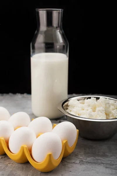 用乡村风格的早餐.牛奶、鸡蛋、深色背景的奶酪 图库图片