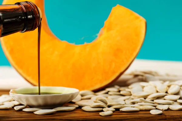 Turuncu balkabağı dilimi, beyaz balkabağı çekirdeği ve kabak yağı.
