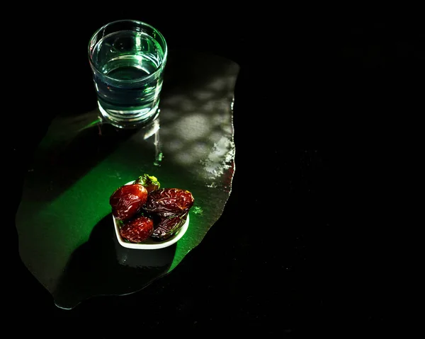 Hermosas fechas, un vaso de agua clara y una linterna Fanus con copyspace — Foto de Stock