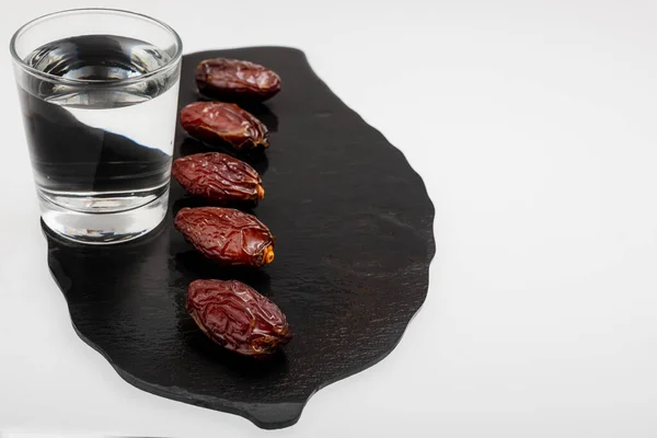 Beş güzel tarih ve siyah bir taşın üzerinde bir bardak temiz su.