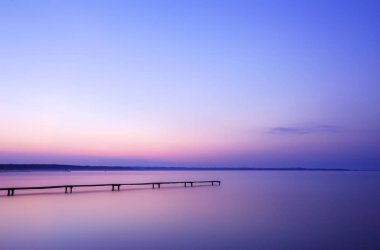 Eski ahşap iskele üzerinde gündoğumu bir gölde