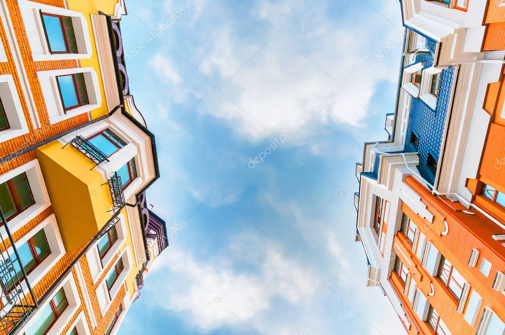 Looking up at tall colorfull residential building with clear sky