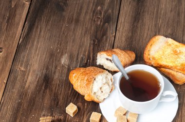 çay bir kruvasan ve eski bir mavi ahşap masa tost ile