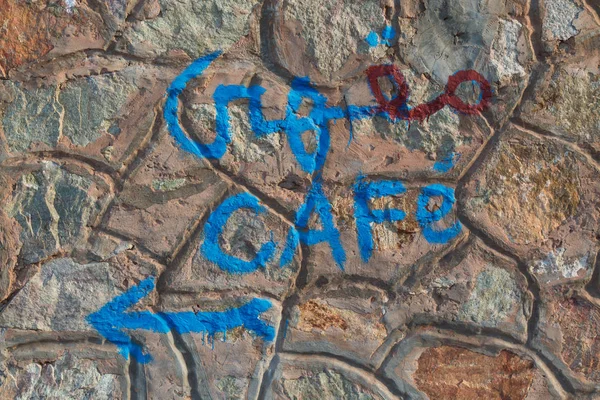 Pared de piedra con una dirección escrita a un café —  Fotos de Stock