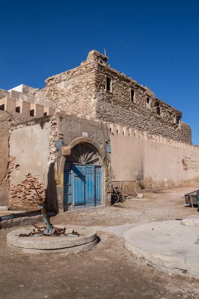 Verlaten stenen gebouw met blauwe poort — Stockfoto