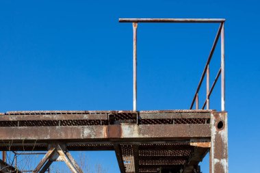 Çakıl çıkarmak için bir bitkinin parçası. Paslı inşaat, korkuluklu bir sahne yaratmak. Parlak mavi gökyüzü. Puste Ulany, Slovakya.