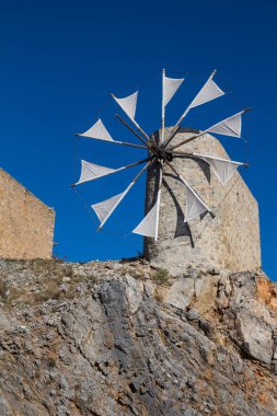 Taştan yapılmış yel değirmenleri, Pinakaino, Lasithi Platosu 'ndaki bir tepede. Parlak mavi gökyüzü. Girit, Yunanistan.