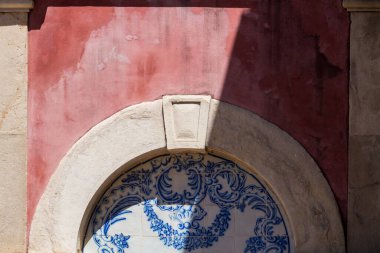 Mavi fayanslar (azulejos), Portekiz geleneksel mimari detayları. Taştan bir kemerle bağlanmış. Bordeaux eski cephe. Kısmen güneş ve gölge. Estoi, Portekiz.