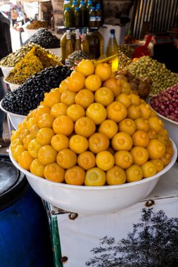 Dükkanlarda çeşitli ürünlerin sunumu için kullanılan tipik yığın: geleneksel yemek tavernasında kullanılan korunmuş limonlar. Arka planda zeytinler var. Essaouira, Fas.