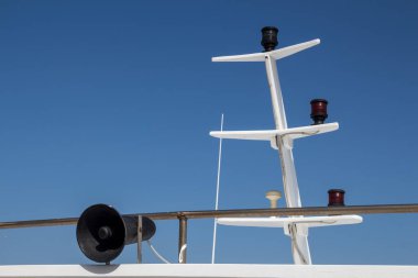 Teknenin beyaz direği ve siyah bir amfinin ayrıntıları. Parlak mavi gökyüzü. Alghero, Sardinya, İtalya.