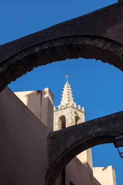 Vista Uma Rua Com Arcos Entre Edifícios Uma Torre Igreja — Fotografia de Stock