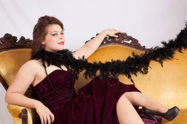 Beautiful woman on a couch with a black boa
