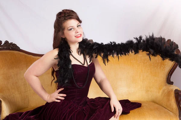 Beautiful woman on a couch with a black boa