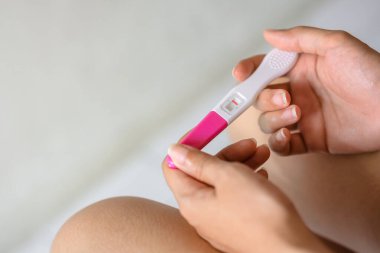 Hamilelik testi tutan mutsuz genç Asyalı kadın tuvaletinde, sağlığında ve sağlıklı konseptinde, kısırlık probleminde, seçici odak noktasında negatif sonuç veriyor..