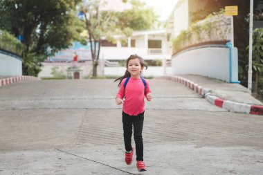 Okul konseptine geri dönersek, Asyalı tatlı çocuk ya da öğrenci sabah okula koşuyor, seçici odaklanma..
