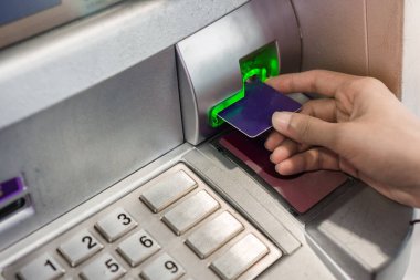 ATM 'den para çekmek için kredi kartı kullanan bir kadının elini kapat..