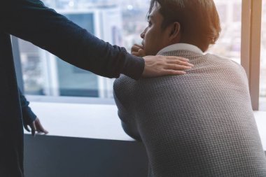 Travma Sonrası Stres Bozukluğu Akıl Sağlığı Konsepti, Psikolog oturmuş ve pencerenin yanında düşük ışık alan Asyalı genç adamı teşvik etmek için dokunuyor..