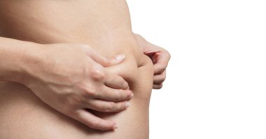 Kapalı kadın eli beyaz arka planda izole edilmiş, kesme yolu ile aşırı göbek yağı tutan.