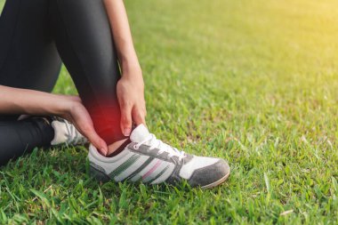 Genç Asyalı kadın spor koşusunda bileğini burkmuş seçici odaklanma, egzersiz ve sağlıklı konsept..