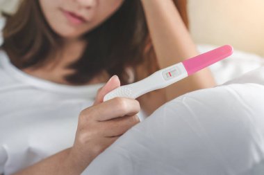 Hamilelik testi tutan mutsuz, genç Asyalı kadın negatif sonuç veriyor, seçmeli odaklanma ve kopyalama alanı, sağlık ve sağlıklı konsept, kısırlık sorunu.
