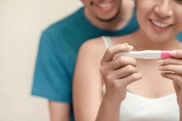 Happy young couple asian woman and man smiling and holding pregnancy test, Wellness and healthy concept, Abortion problem, Selective focus.