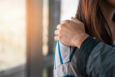 Psikolog, düşük ışık ortamı, seçici odaklanma, PTSD Akıl Sağlığı Konsepti ile pencerenin yakınındaki depresif Asyalı genç kadına dokunuyor..