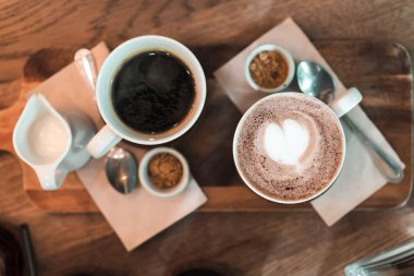 Süt köpüklü kahve bardağının üst görüntüsü ahşap masada, seçici odaklanma..