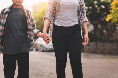 Anne ya da baba, sırt çantalı çocuk ya da öğrenciyle el ele tutuşuyor okula geri dönüyor, okul konseptine dönüyor, seçmeli odaklanıyor..