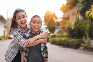 Mutlu anne kucaklaması ya da okula gitmeden önce sırt çantalı bir öğrenci, okula dönüş konsepti, seçmeli odaklanma.