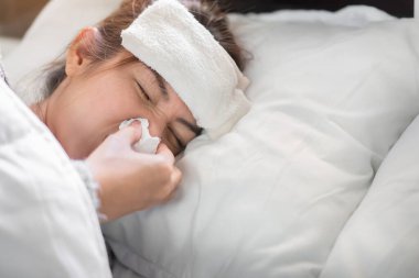 Hasta Asyalı kadın yatakta grip ve hastalıkla boğuşuyor. Tıbbi ve sağlık konsepti, seçici odaklanma..