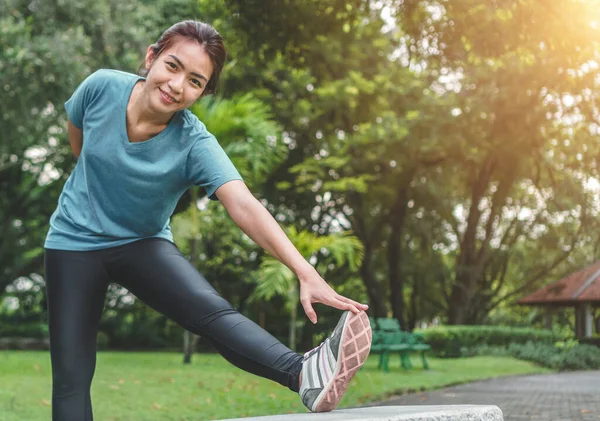 Young asian woman runner stretching arm and leg before running at morning,  Exercise concept. — Exercising, beautiful - Stock Photo | #377340510