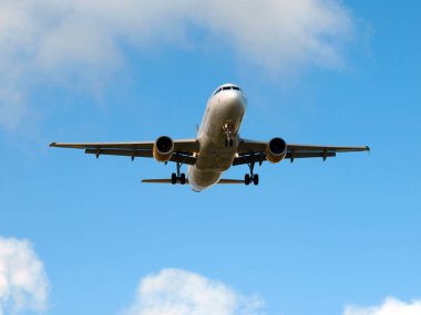 Güneşli bir günde mavi gökyüzüne inen bir uçak.