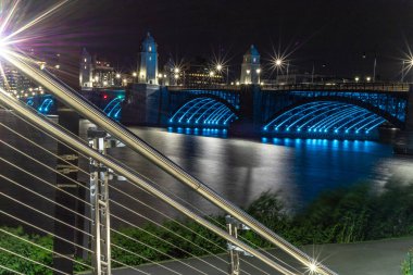 Geceleri köprünün altında mavi ışıklar parlıyor. (Charles River, Boston, Massachusetts, ABD)