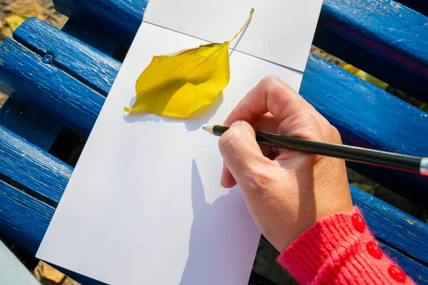 Um bloco de notas em branco para planejamento, resumindo. A mão segura o lápis. Ela vai desenhar ou manter um bloco de notas . — Fotografia de Stock