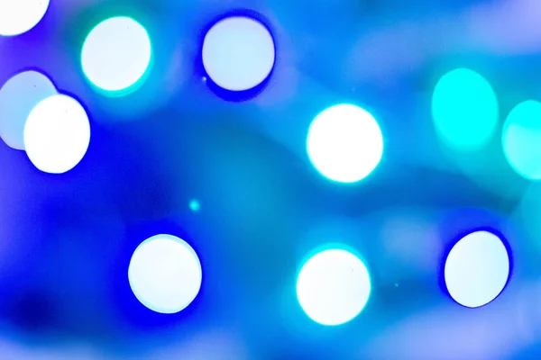 Karanlık arka planda Bokeh. Bulanık Noel ve yeni yıl ışıkları. Geçmişi. Saf mavi, kırmızı, yeşil.