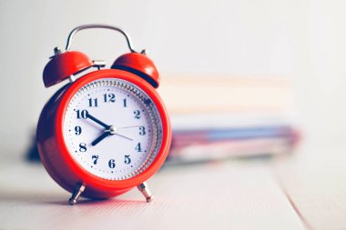 Kitap arkaplanındaki turuncu mekanik saat. Beyaz arka grup