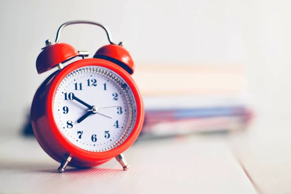 Kitap arkaplanındaki turuncu mekanik saat. Beyaz arka grup