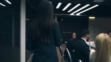 İş kadını odaya giriyor ve iş arkadaşlarıyla konuşuyor. yavaş çekim