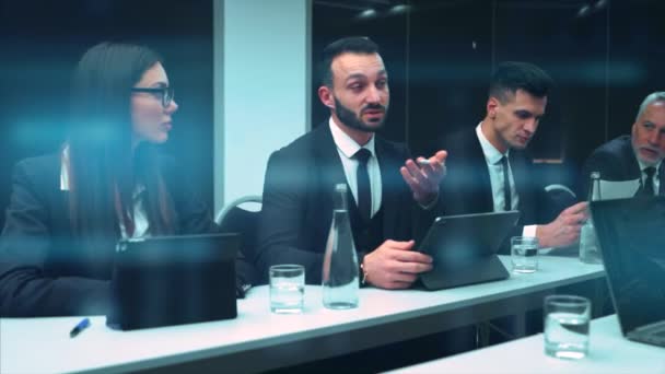 若い実業家はテーブルに座って話をする スローモーション — ストック動画