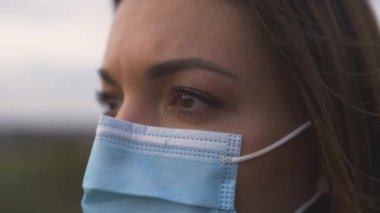 Dışarıda duran tıbbi maskeli çekici kız. yavaş çekim