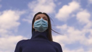 Dışarıda duran tıbbi maskeli çekici kadın. yavaş çekim