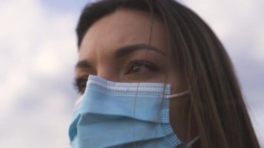 Dışarıda duran tıbbi maskeli çekici kız. yavaş çekim