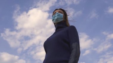 Dışarıda duran tıbbi maskeli güzel kadın. yavaş çekim
