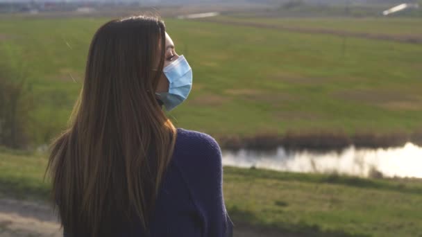 아름다운 소녀가 언덕에 의료용 마스크를 — 비디오