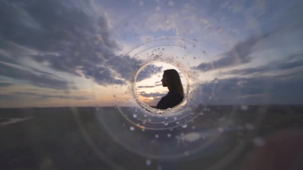 Die Frau Gegen Den Sonnenuntergang Blick Durch Das Transparente Rohr — Stockvideo