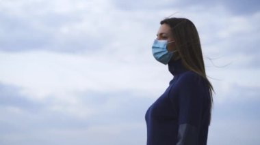Dışarıda duran tıbbi maskeli çekici kız. yavaş çekim