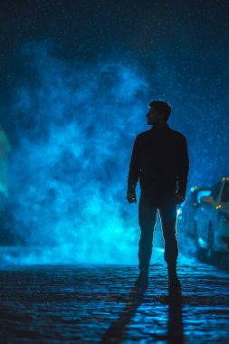Smoky caddesinde duran adam. İyi akşamlar gece. Telefoto mercek görüntüsü