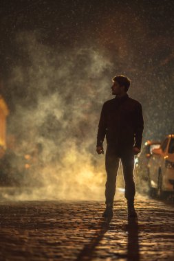Smoky caddesinde duran adam. İyi akşamlar gece. Telefoto mercek görüntüsü